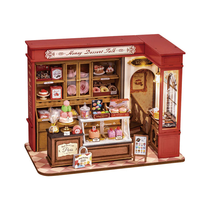 Cosy miniature pâtisserie kitchen with shelves of French desserts and tea.